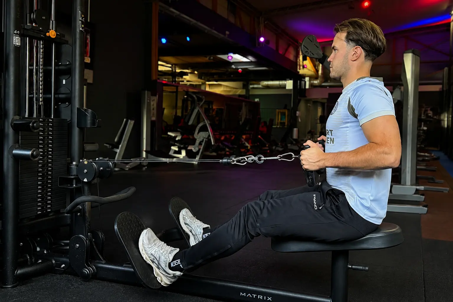 Sporter traint zijn rug op een kabeltoestel bij Fitland Gemert